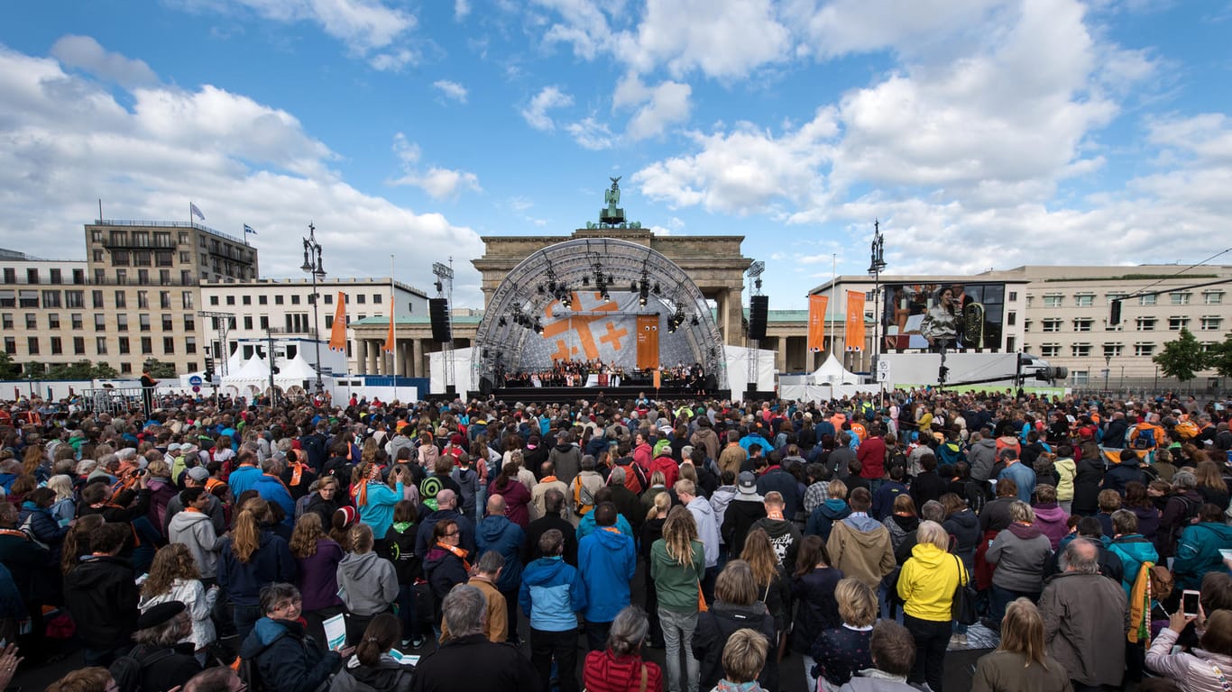 Zahlreiche Besucher verfolgen einen der Eröffnungsgottesdienste am Brandenburger Tor in Berlin.