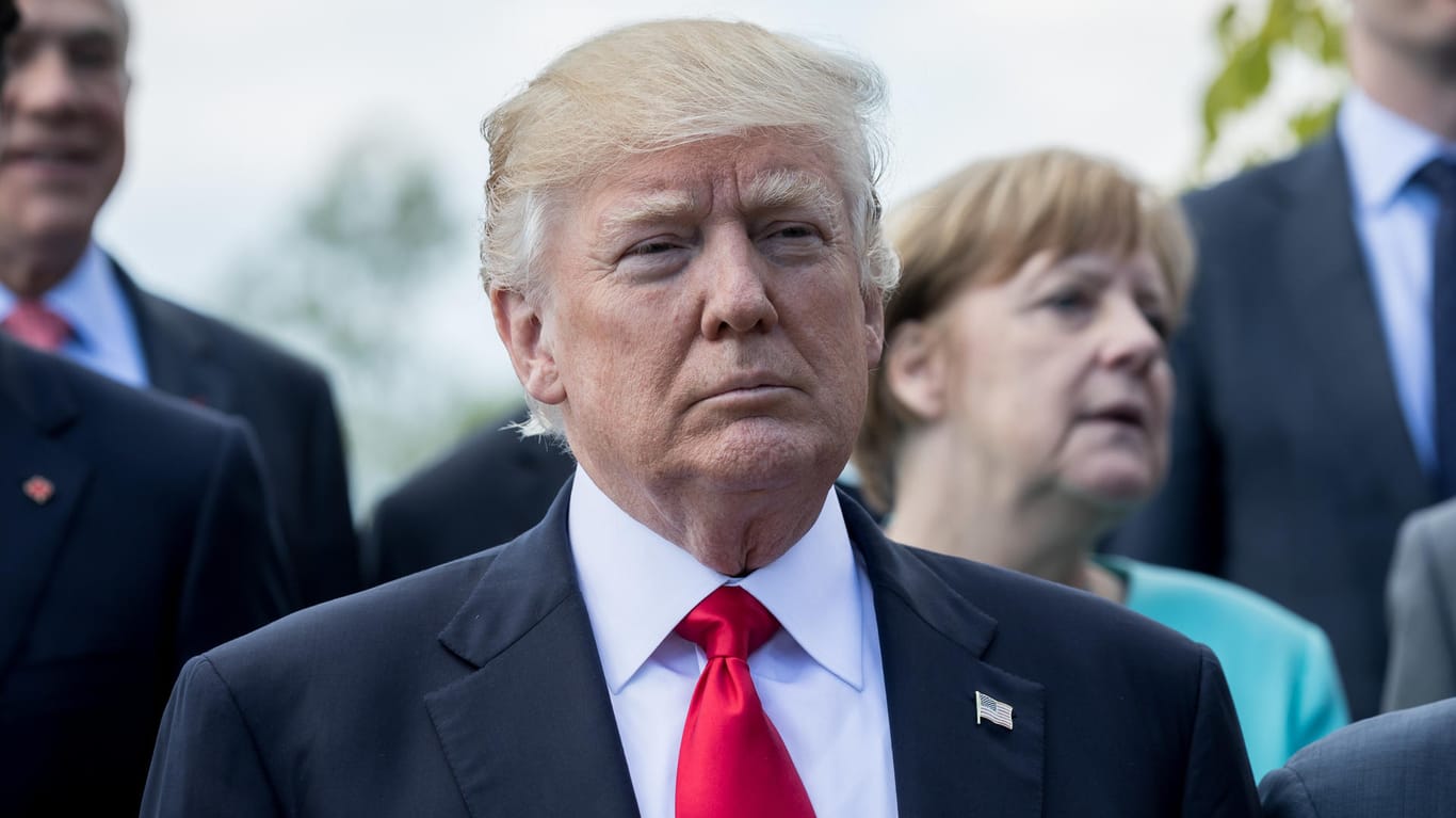 US-Präsident Donald Trump steht vor Bundeskanzlerin Angela Merkel beim Familienfoto der G7 Staaten.