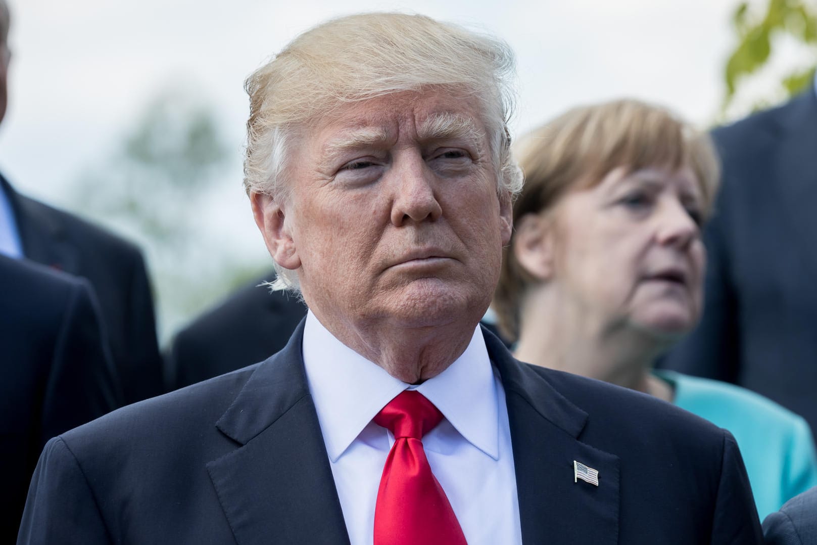 US-Präsident Donald Trump steht vor Bundeskanzlerin Angela Merkel beim Familienfoto der G7 Staaten.