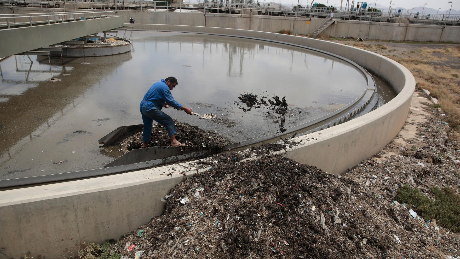 Ein jemenitische Mann säubert am 27.05.2017 ein Wasserwiederaufbereitungsbecken in einer Kläranlage in Sanaa (Jemen).