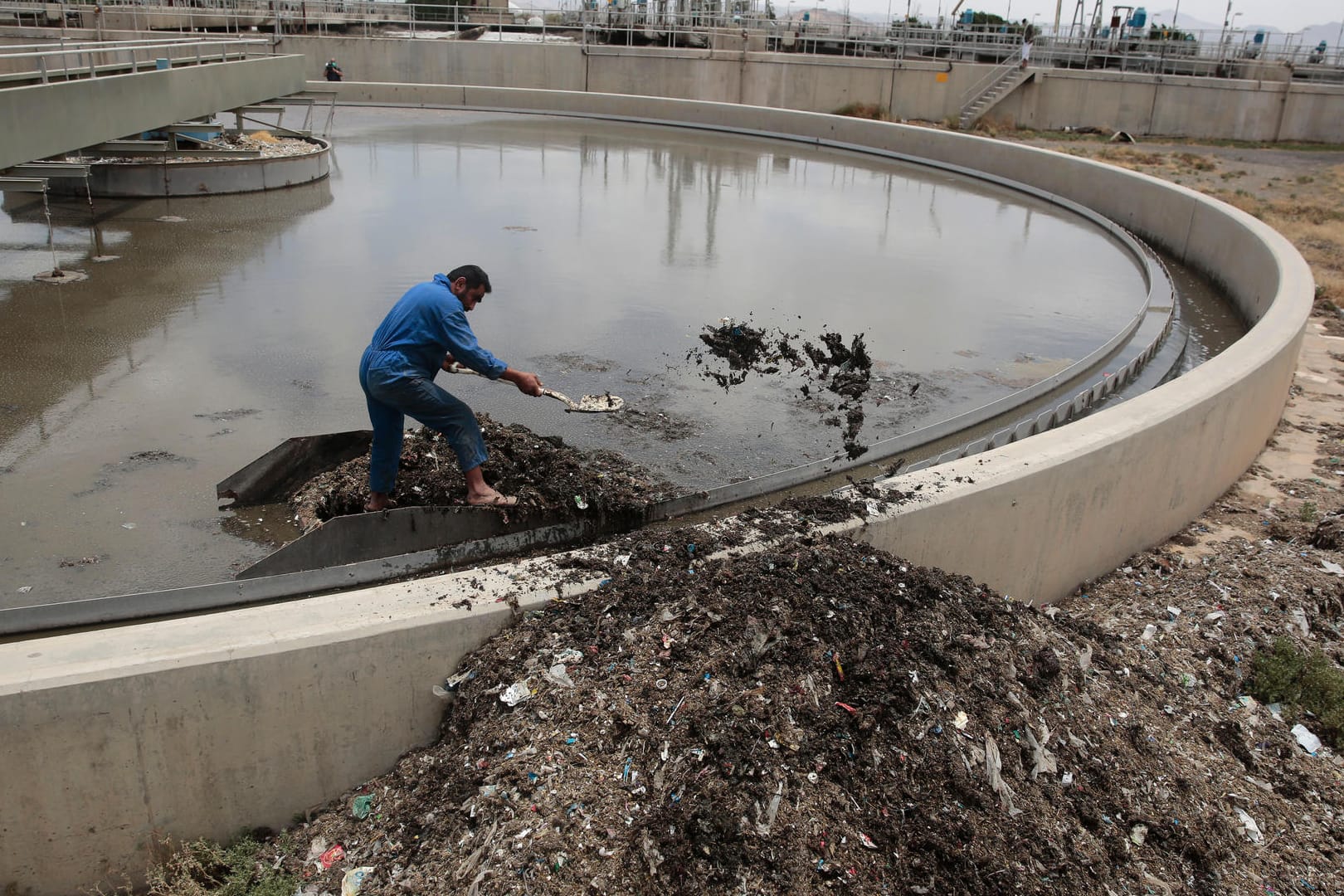 Ein jemenitische Mann säubert am 27.05.2017 ein Wasserwiederaufbereitungsbecken in einer Kläranlage in Sanaa (Jemen).