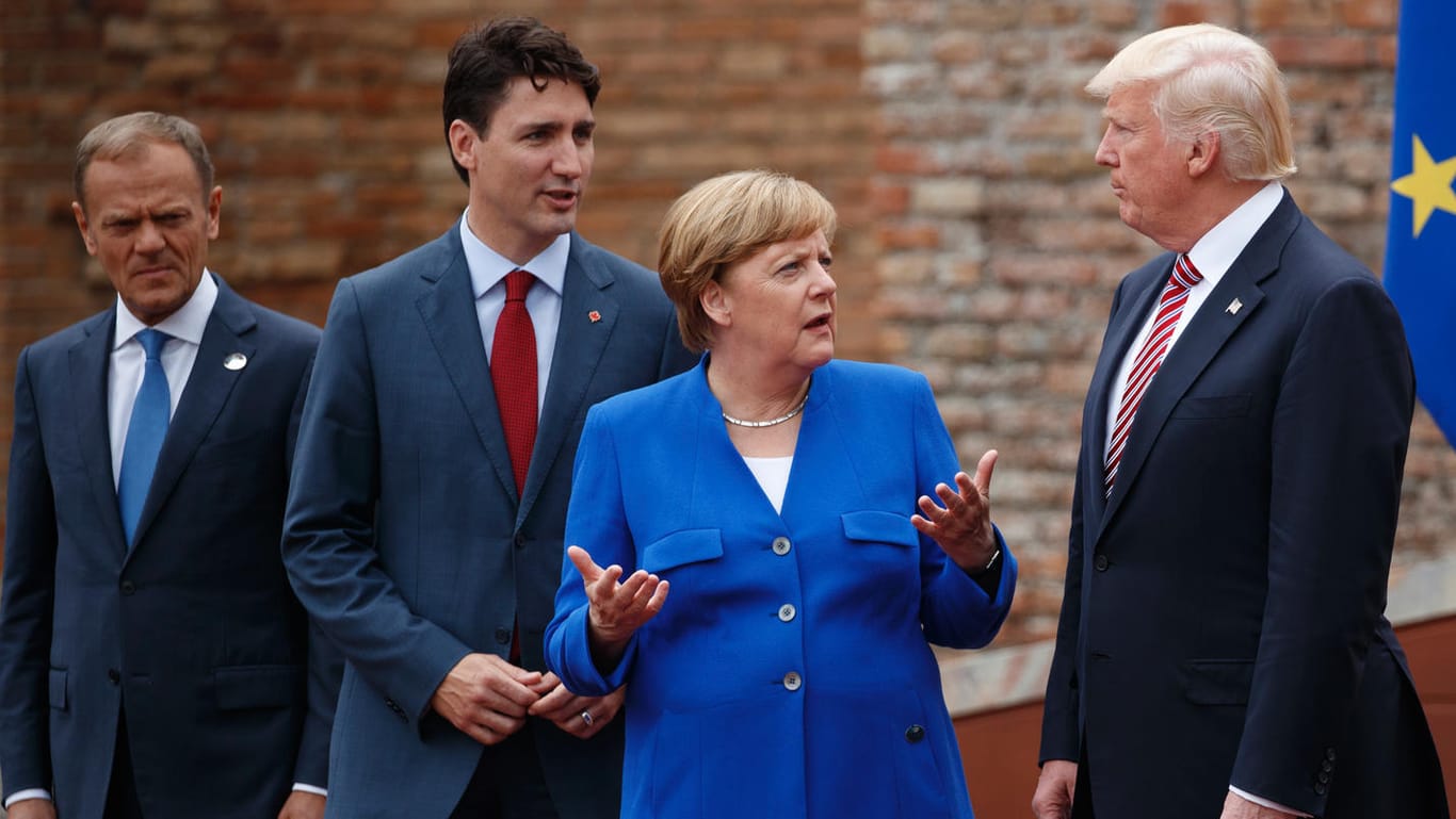 Angela Merkel diskutiert beim G7-Gipfel mit Donald Trump. Justin Trudeau und Donald Tusk lauschen von der Seite.