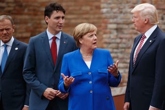 Angela Merkel diskutiert beim G7-Gipfel mit Donald Trump. Justin Trudeau und Donald Tusk lauschen von der Seite.