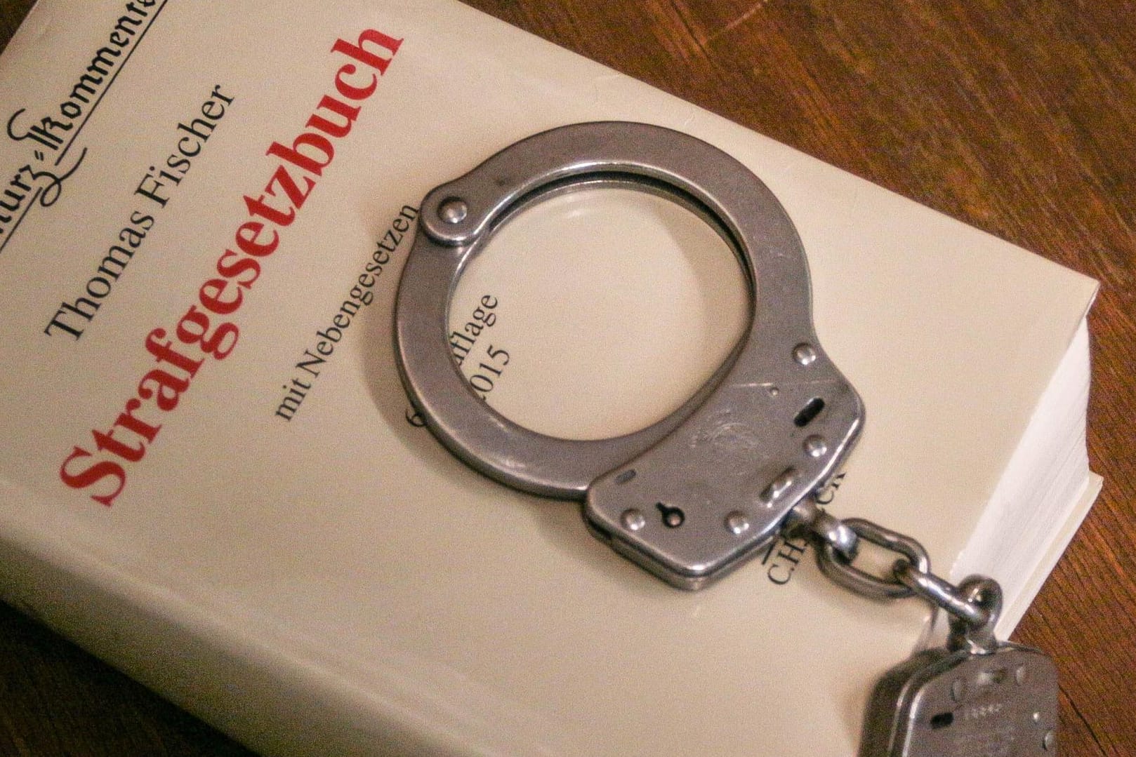 Handschellen liegen auf einem Strafgesetzbuch: Der Bundestag hat die Abschaffung des Strafrechtsparagrafen 103 beschlossen.