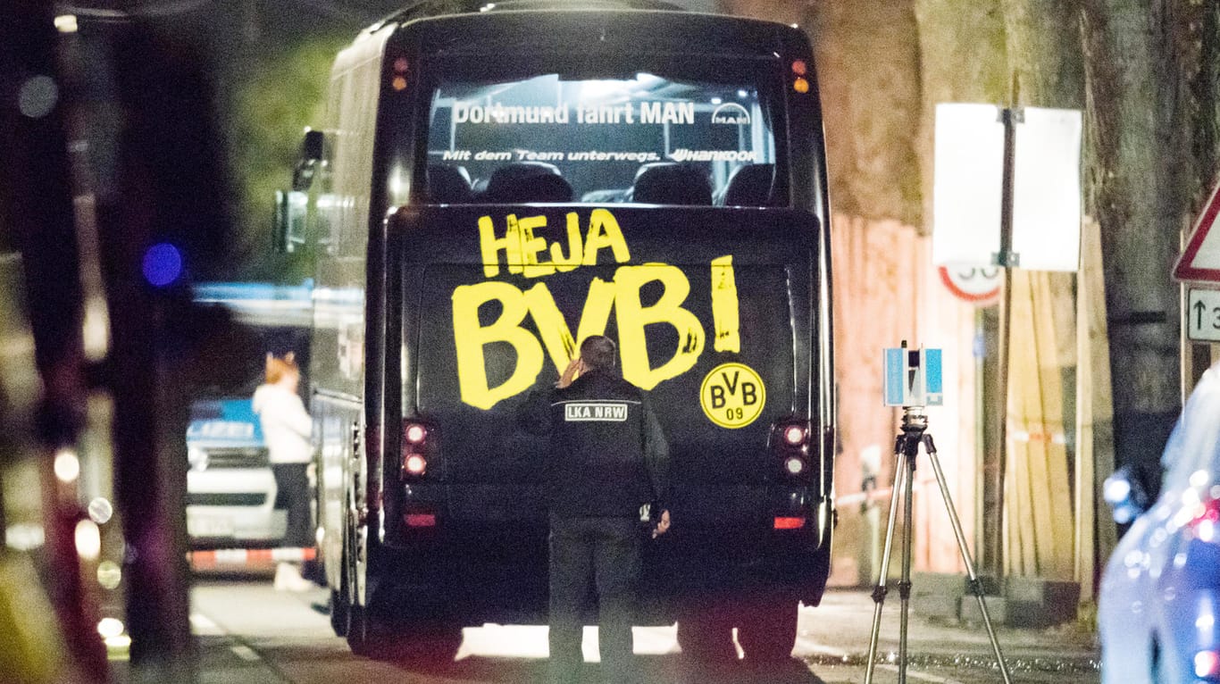 Ein Beamter des Landeskriminalamtes (LKA) untersucht, in der Nacht nach dem Anschlag, den Mannschaftsbus von Borussia Dortmund.