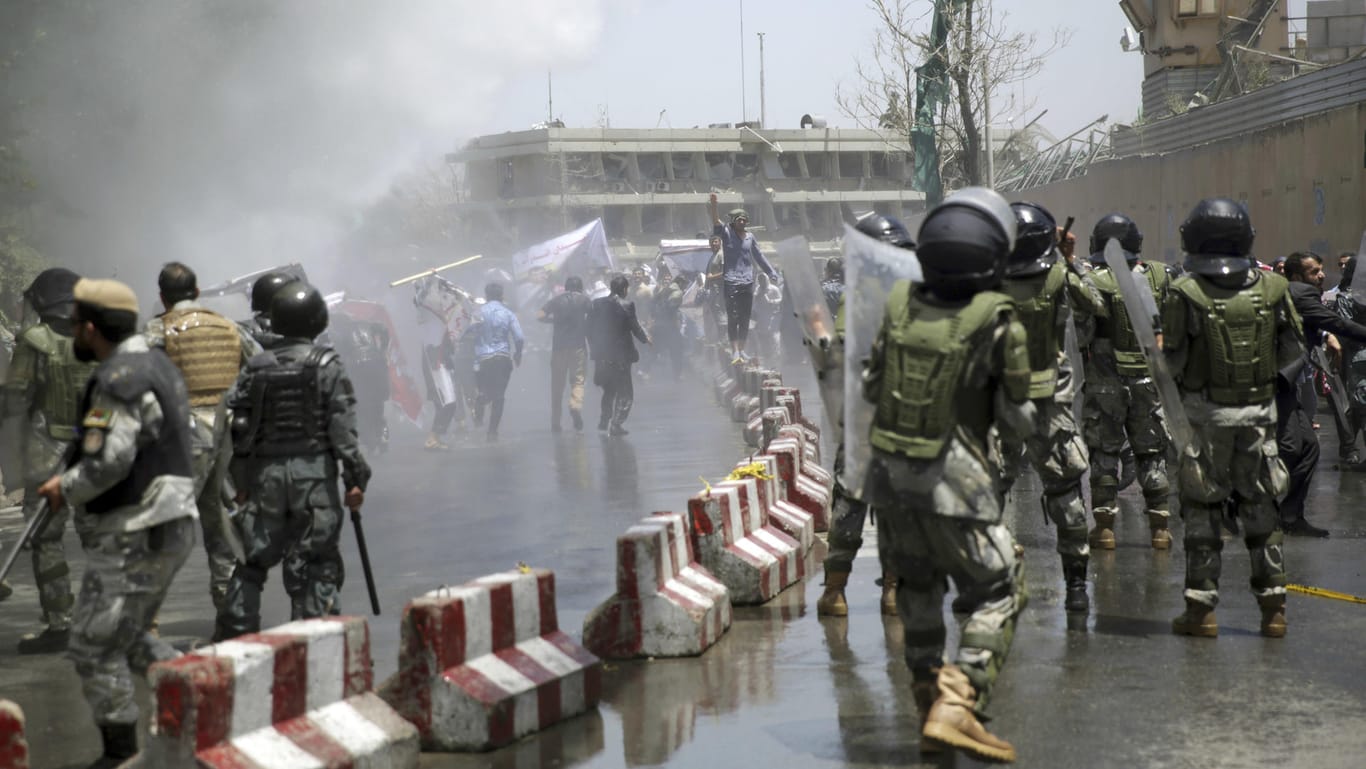 Polizisten stehen in Kabul Demonstranten gegenüber.