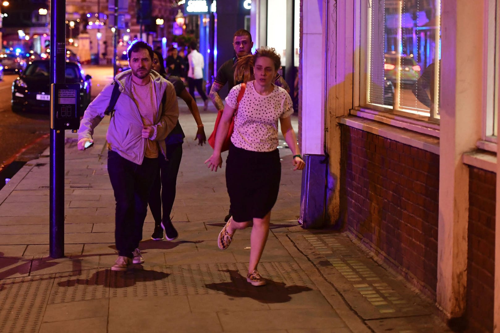 Menschen rennen auf der Borough High Street weg von der London Bridge.