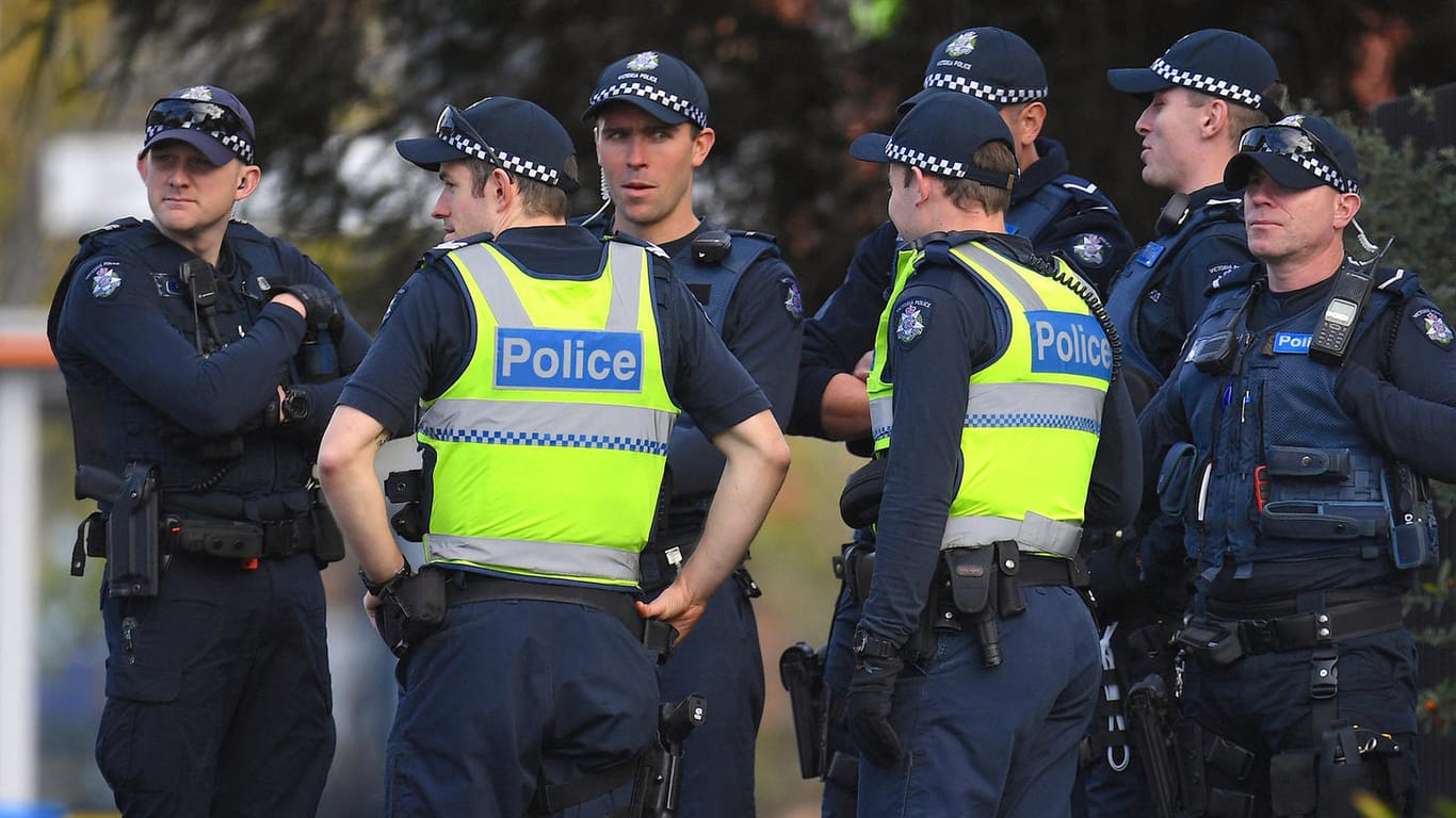 Polizisten warten vor dem Gebäude: Bei der Geiselnahme in Melbourne starben zwei Menschen, eine Frau konnte befreit werden.
