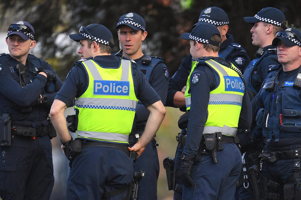 Polizisten warten vor dem Gebäude: Bei der Geiselnahme in Melbourne starben zwei Menschen, eine Frau konnte befreit werden.