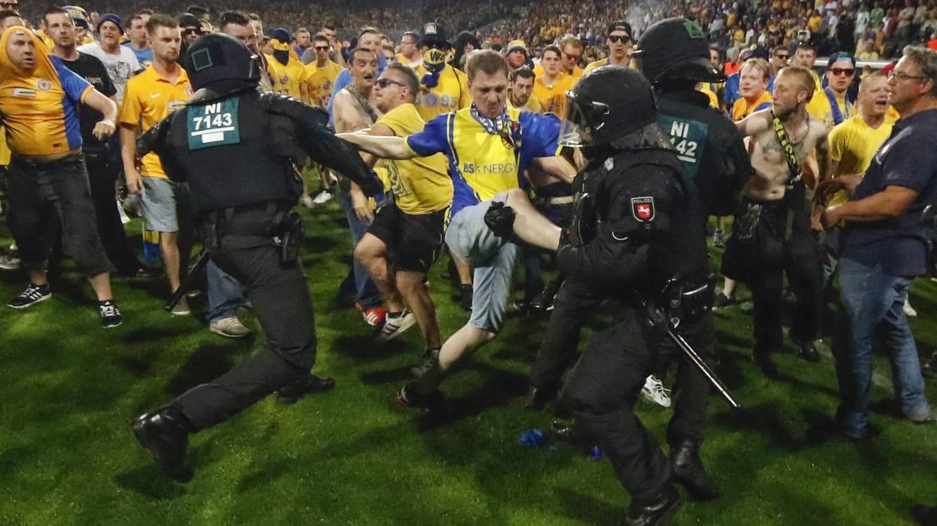 Hässliche Szenen nach Abpfiff in Braunschweig: Eintracht-Fans stürmen den Platz und gehen auf Polizisten los. Hässliche Szenen nach Abpfiff in Braunschweig: Eintracht-Fans stürmen den Platz und gehen auf Polizisten los.
