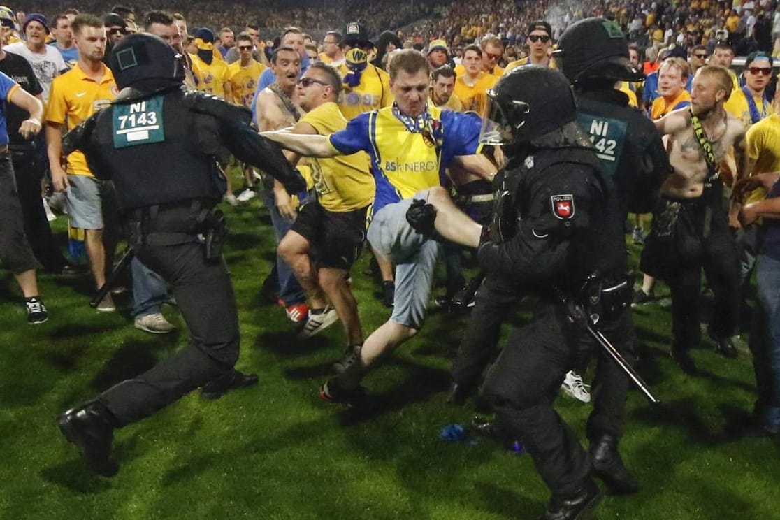 Hässliche Szenen nach Abpfiff in Braunschweig: Eintracht-Fans stürmen den Platz und gehen auf Polizisten los.
