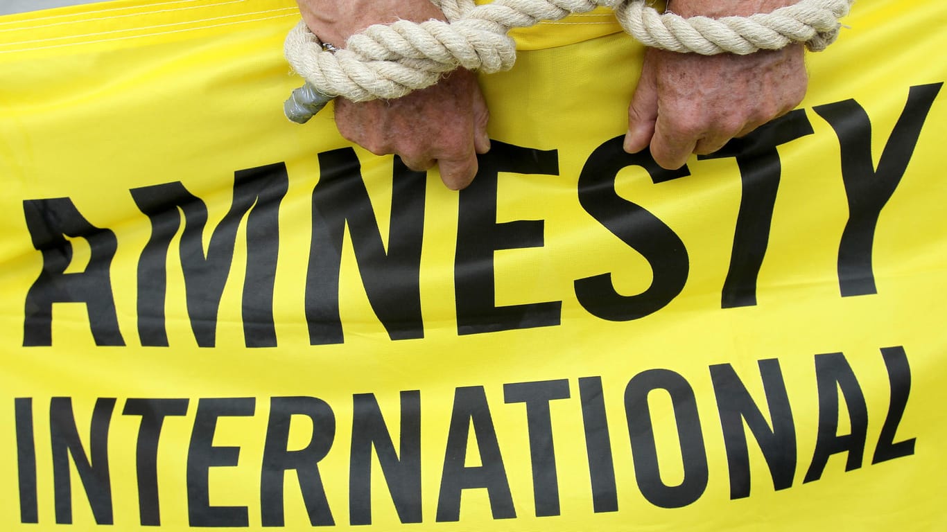 Ein Aktivist von Amnesty International mit symbolischen Fesseln.