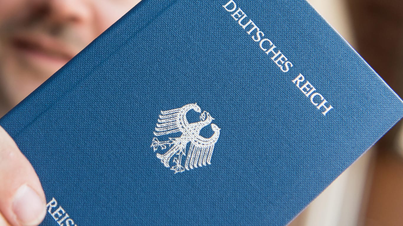 Ein Mann hält in Rheinfelden (Baden-Württemberg) ein Heft mit dem Aufdruck «Deutsches Reich Reisepass» in der Hand.