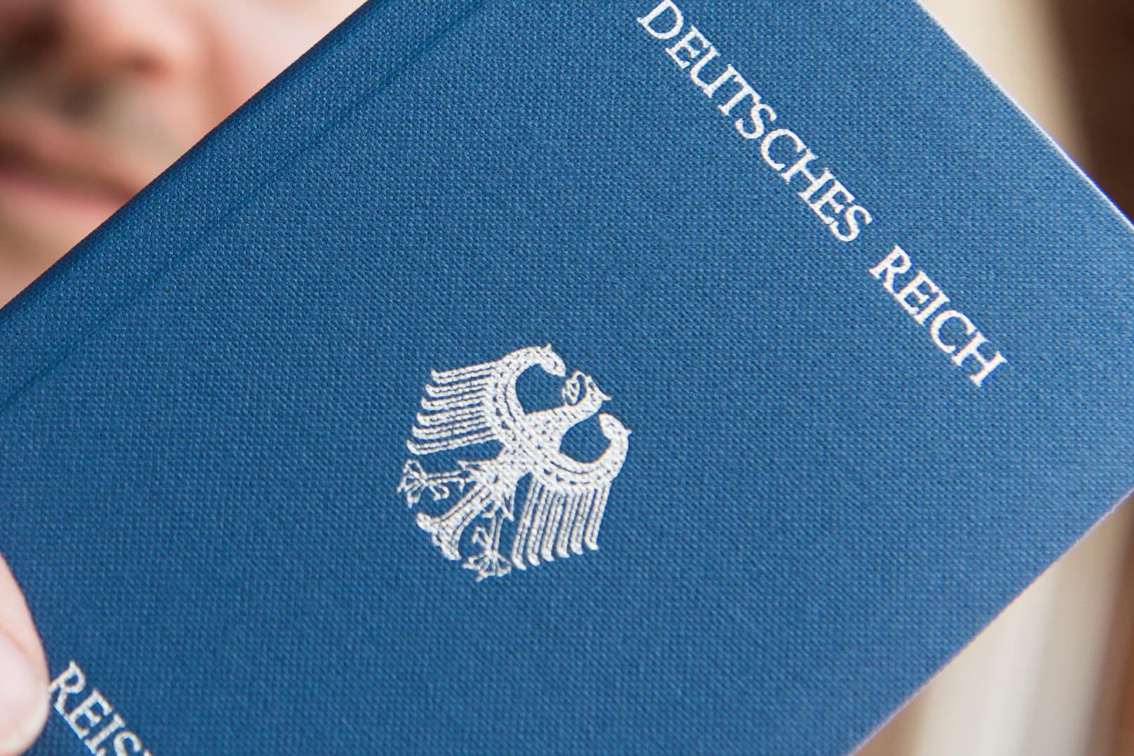 Ein Mann hält in Rheinfelden (Baden-Württemberg) ein Heft mit dem Aufdruck «Deutsches Reich Reisepass» in der Hand.