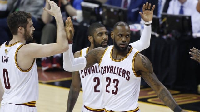 LeBron James (r) von den Cleveland Cavaliers jubelt mit seinen Mannschaftskollegen Kevin Love (l) and Kyrie Irving (M).