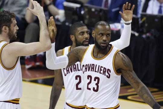 LeBron James (r) von den Cleveland Cavaliers jubelt mit seinen Mannschaftskollegen Kevin Love (l) and Kyrie Irving (M).