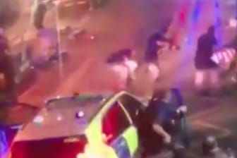 Mitten im Chaos umringen Polizisten einen der Attentäter auf der rechten Seite des Bildes.