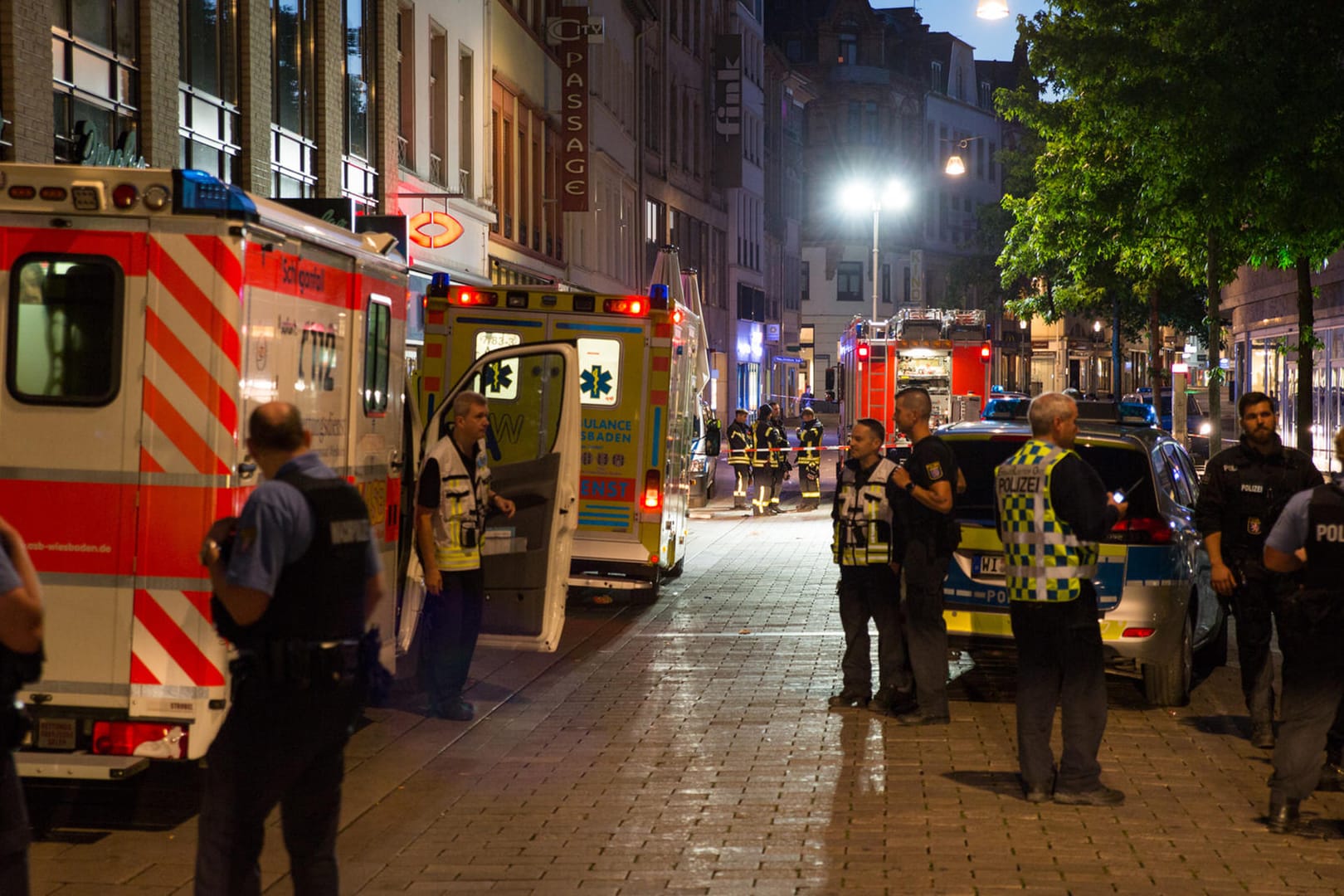 Polizisten, Feuerwehrleute und Sanitäter sperren den Tatort in der Fußgängerzone der Wiesbadener Innenstadt ab.