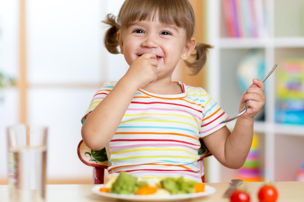 Ein Kind isst Gemüse