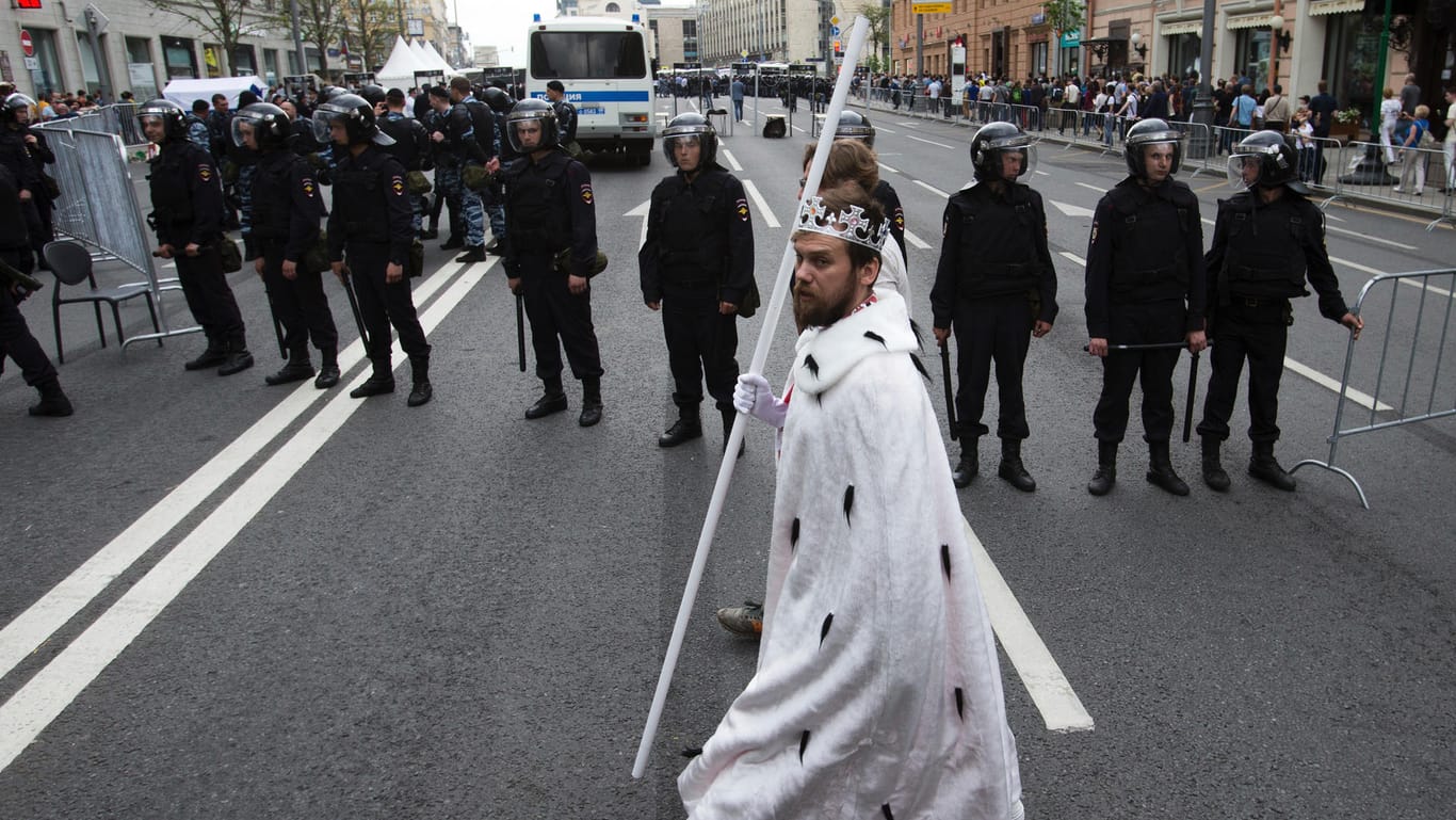 Ein kostümierter Darsteller des Fests zum "Tag Russlands" läuft in Moskau an Polizisten vorbei.