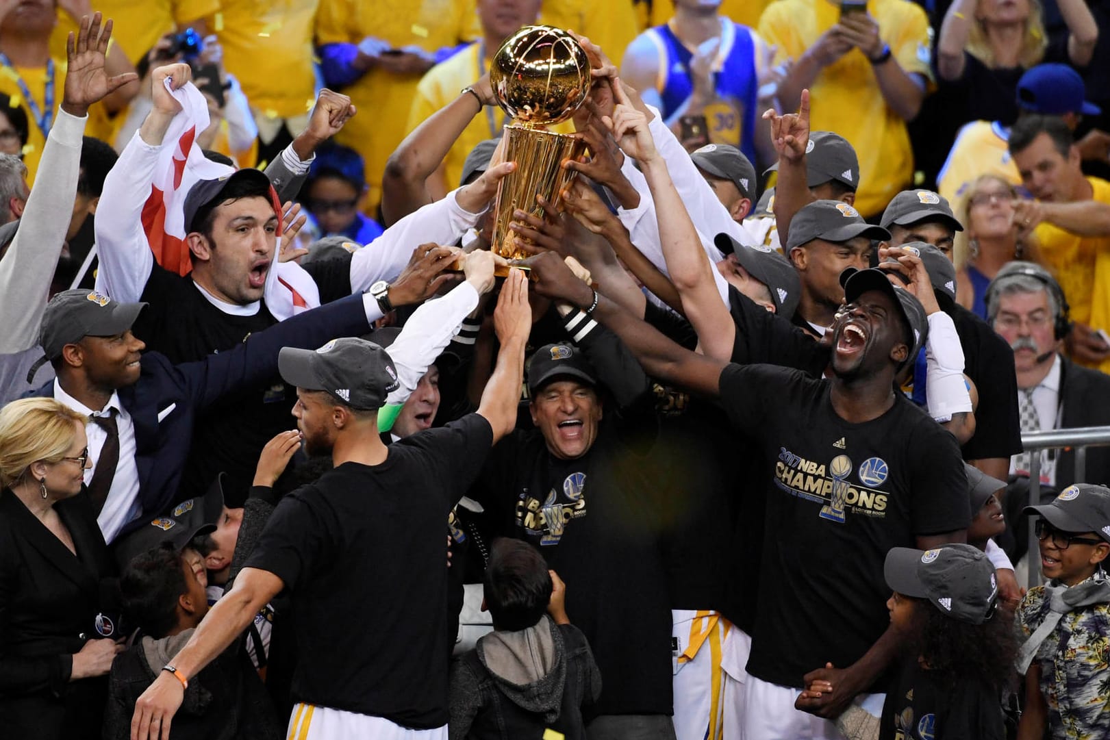 Spieler und Trainer der Golden State Warriors stemmen die NBA-Trophäe in die Luft.