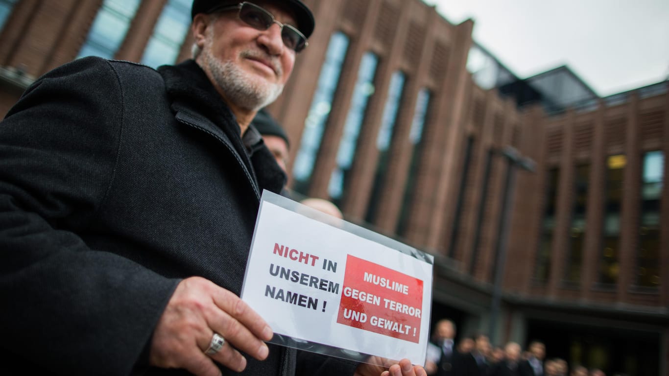 Ein Muslim mit einem Schild mit der Aufschrift "Nicht in unserem Namen! Muslime gegen Terror und Gewalt" steht am 16.01.2015 in Köln.