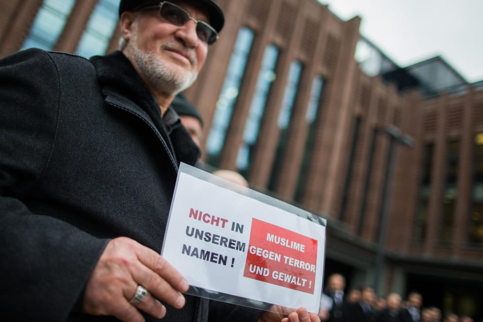 Ein Muslim mit einem Schild mit der Aufschrift "Nicht in unserem Namen! Muslime gegen Terror und Gewalt" steht am 16.01.2015 in Köln.
