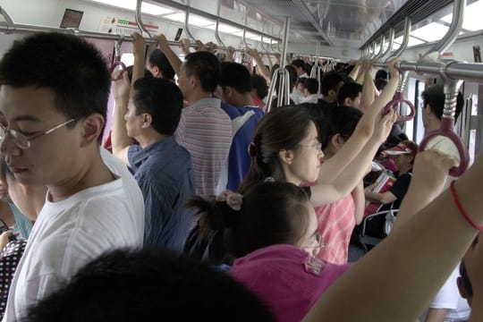Menschen über Menschen in in einer U-Bahn in Peking während der Olympischen Spiele.