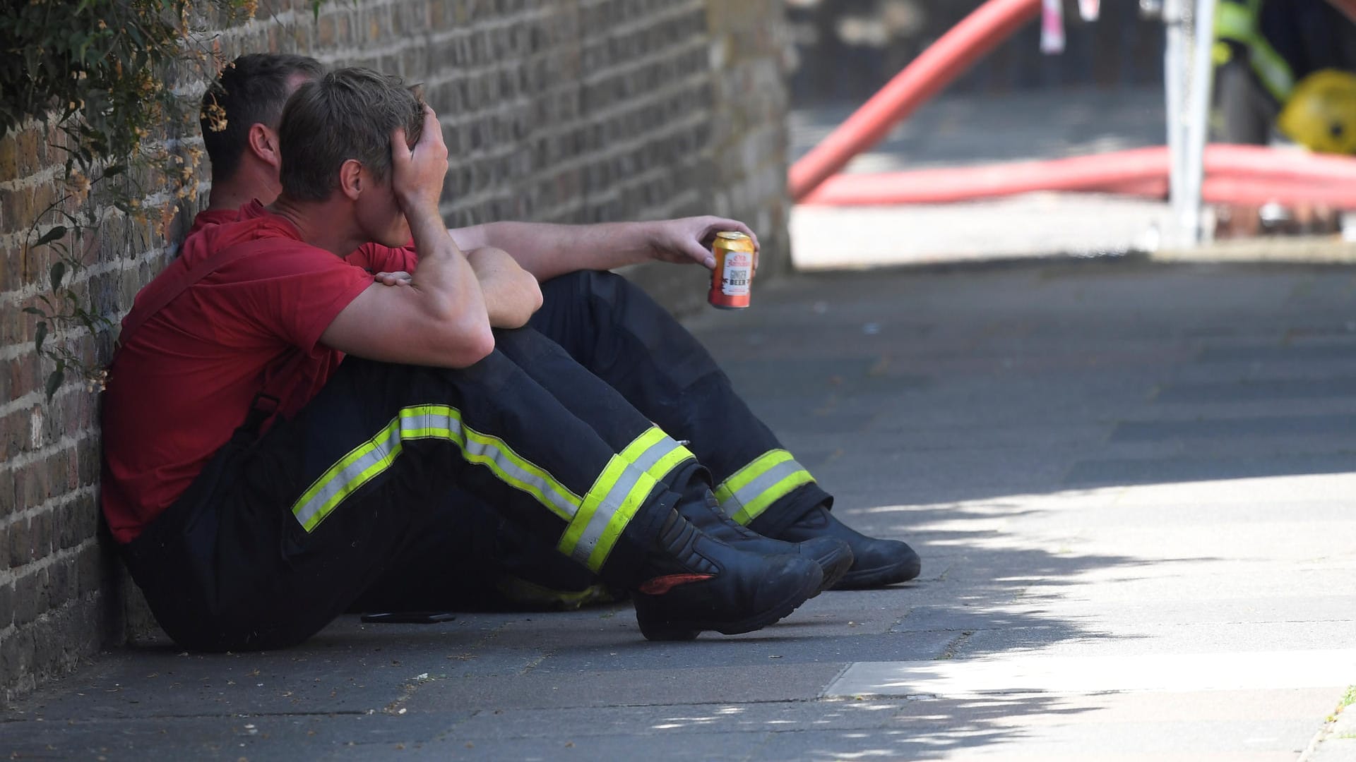 Feuerwehrmänner ruhen sich nach dem kräftezehrenden Einsatz im Grenfell Tower aus.