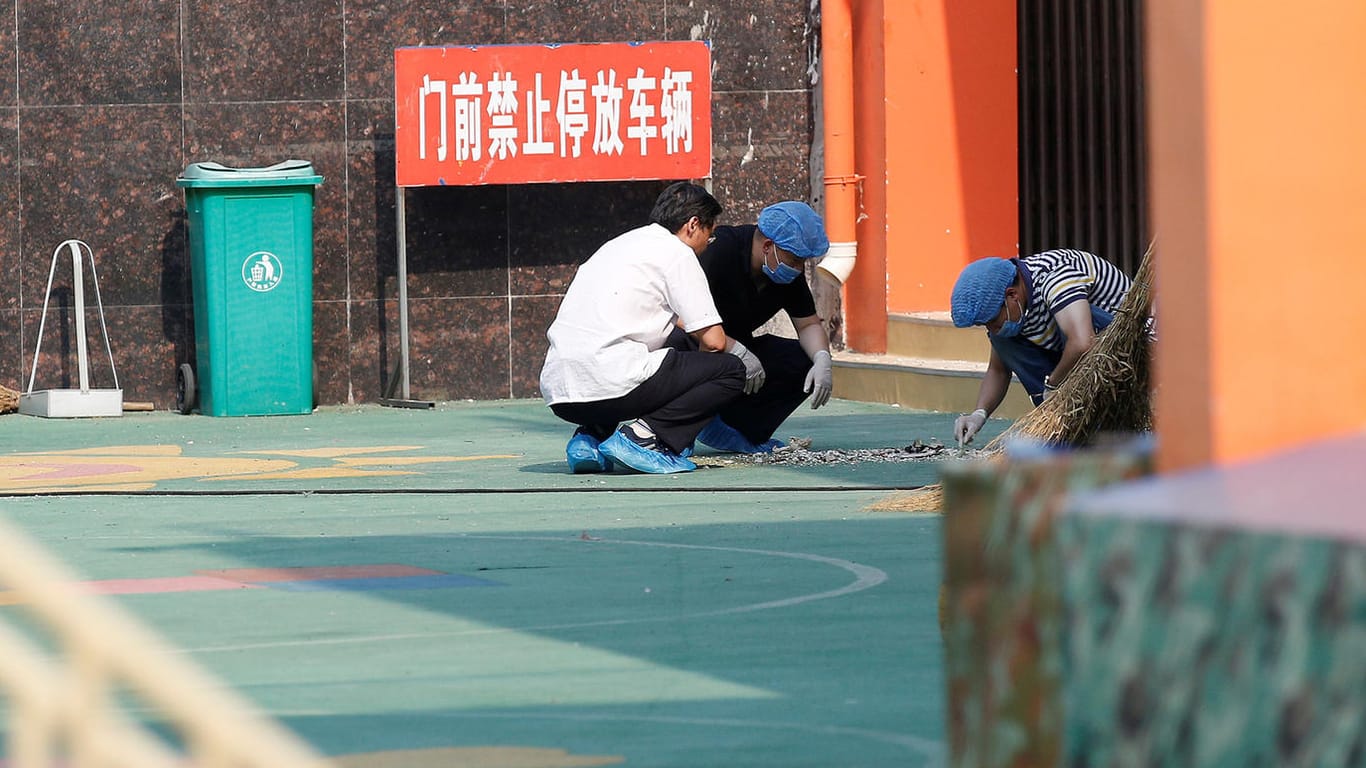Ermittler untersuchen Spuren am Ort der Explosion vor einem Kindergarten in Ostchina.