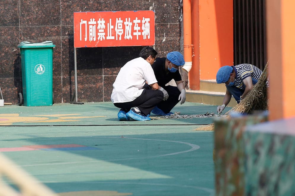 Ermittler untersuchen Spuren am Ort der Explosion vor einem Kindergarten in Ostchina.