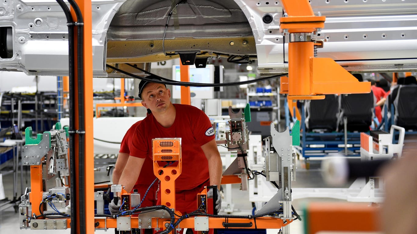 Mitarbeiter montieren im neuen Volkswagen Nutzfahrzeug (VWN) - Werk für den neuen Lieferwagen Crafter in Wrzesnia bei Posen (Polen) ein Fahrzeug. Die Stärke der deutschen Wirtschaft sichert in den übrigen Staaten der Europäischen Union Jobs.