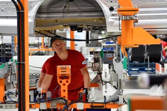 Mitarbeiter montieren im neuen Volkswagen Nutzfahrzeug (VWN) - Werk für den neuen Lieferwagen Crafter in Wrzesnia bei Posen (Polen) ein Fahrzeug. Die Stärke der deutschen Wirtschaft sichert in den übrigen Staaten der Europäischen Union Jobs.