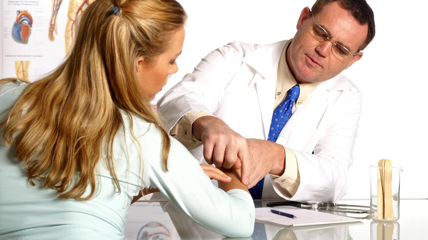 Ein Arzt untersucht die Leberflecke einer jungen Frau. (Symbolbild)