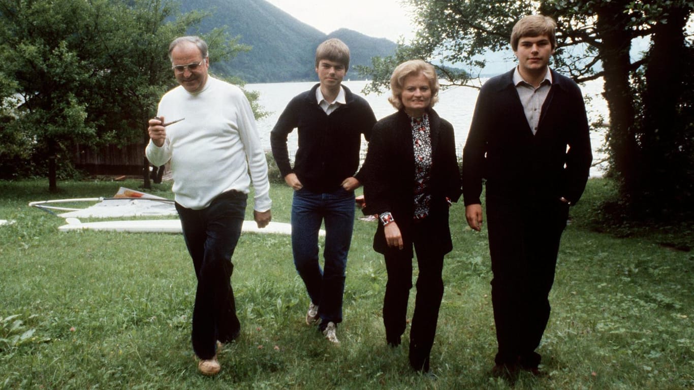 Bundeskanzler Helmut Kohl, seine Gattin Hannelore und die Söhne Walter und Peter laufen im Juni 1981 über eine grüne Wiese am Wolfgangsee.