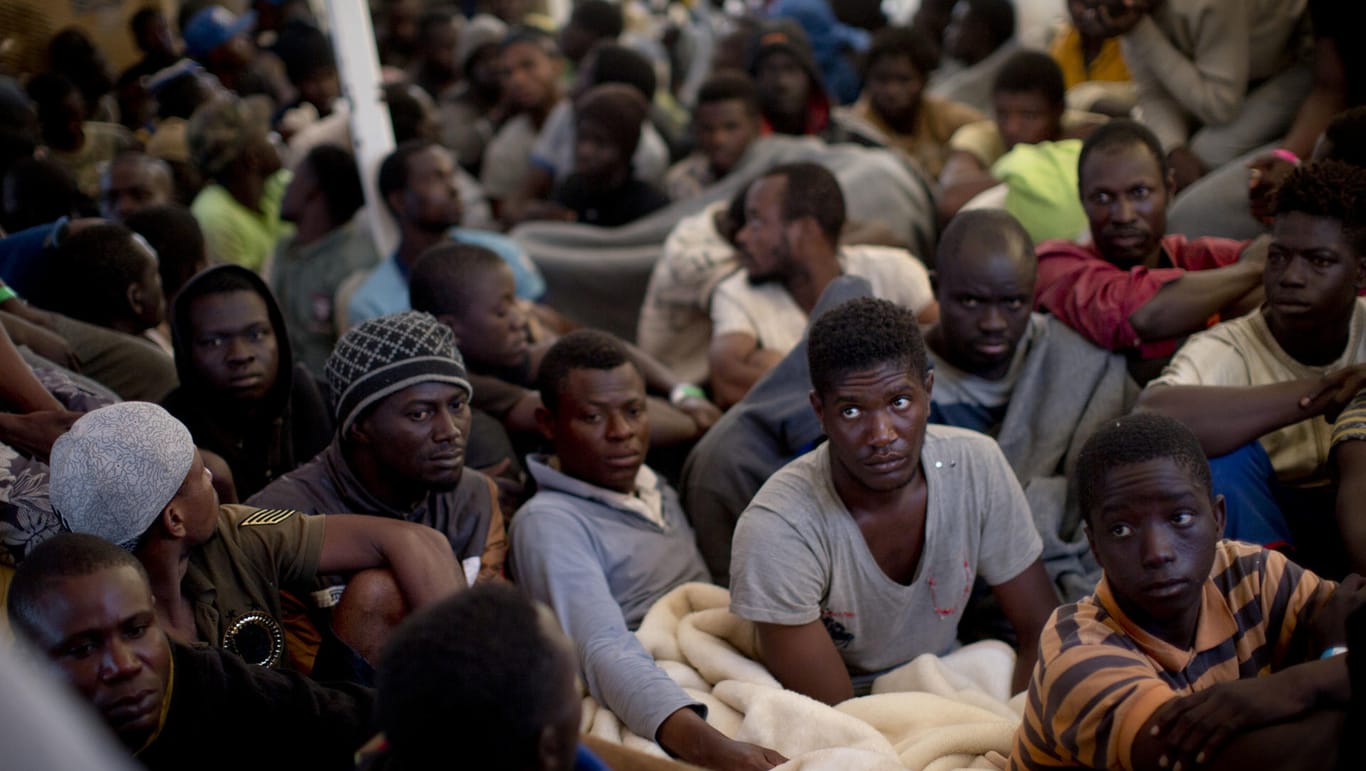 Männer sitzen im Mittelmeer an Bord des Rettungsschiffes Golfo Azzuro, nachdem sie von der spanischen Hilfsorganisation "Proactiva Open Arms" gerettet wurden.