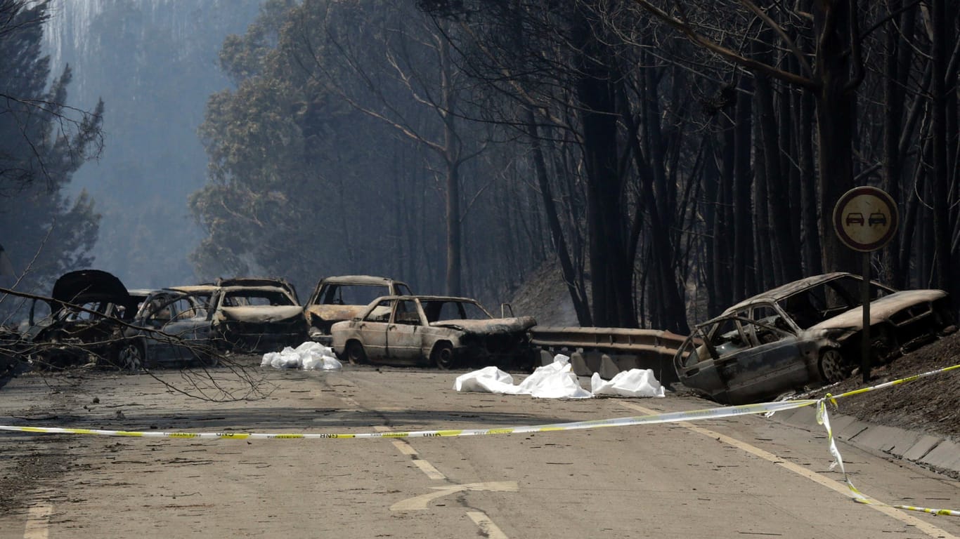 Ausgebrannte Autos stehen auf einer Straße zwischen Castanheira de Pera un Figueiro dos Vinhos in Portugal.