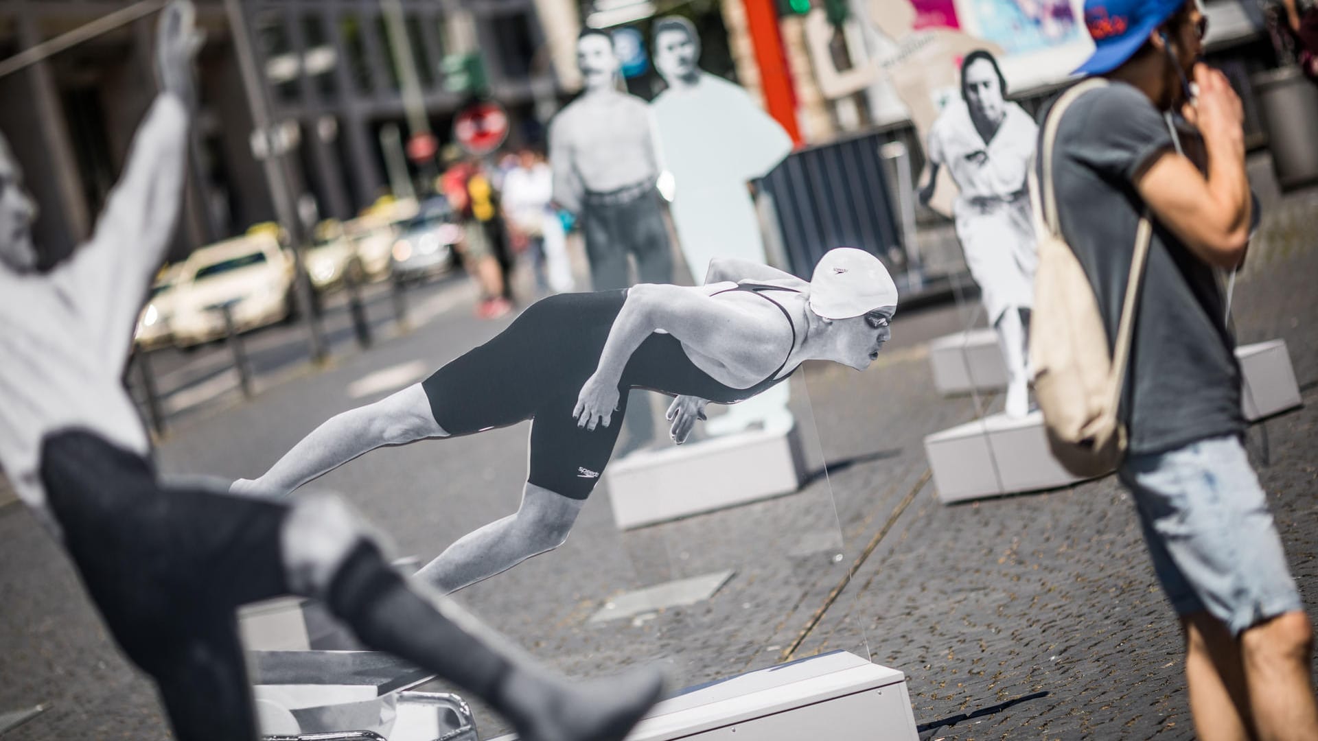 Ein Passant steht auf dem Rathenauplatz in Frankfurt am Main vor einem lebensgroßen Bild der Schwimmerin Sarah Poewe (M), der ersten jüdischen Athletin, die nach dem Ende des Zweiten Weltkrieges eine olympische Medaille für Deutschland errang. Die Freiluft-Ausstellung läuft unter dem Titel "Zwischen Erfolg und Verfolgung. Jüdische Stars im deutschen Sport bis 1933 und danach" Ein Passant steht auf dem Rathenauplatz in Frankfurt am Main vor einem lebensgroßen Bild der Schwimmerin Sarah Poewe (M), der ersten jüdischen Athletin, die nach dem Ende des Zweiten Weltkrieges eine olympische Medaille für Deutschland errang. Die Freiluft-Ausstellung läuft unter dem Titel "Zwischen Erfolg und Verfolgung. Jüdische Stars im deutschen Sport bis 1933 und danach"