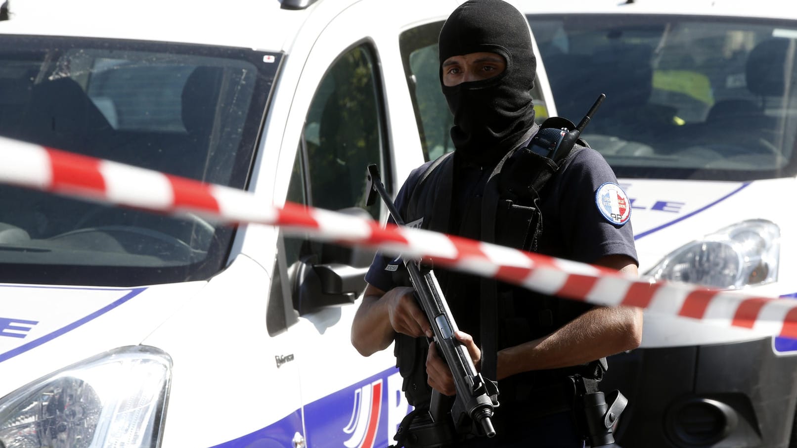 Ein Polizist steht auf den die Champs Elysees in Paris hinter einem Absperrband.