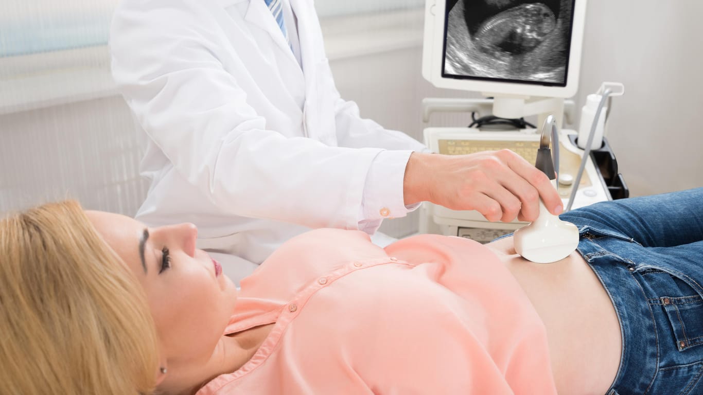 Arzt untersucht den Bauch einer Schwangeren per Ultraschall