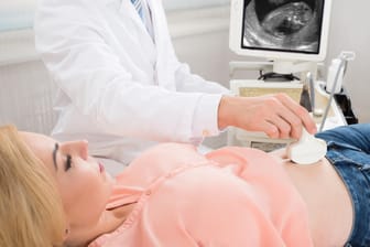 Arzt untersucht den Bauch einer Schwangeren per Ultraschall