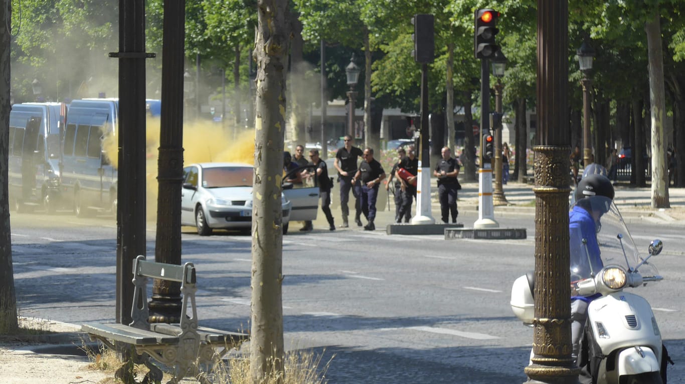 Polizisten löschen auf den Champs Elysees in Paris das Auto, mit dem Mann zuvor ein Polizei-Fahrzeug gerammt hatte