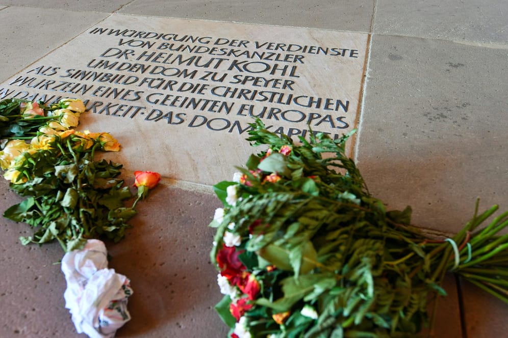 Neben einer Bodenplatte mit einer Danksagung an Helmut Kohl liegen in Speyer im Kaiserdom mehrere Blumensträuße.