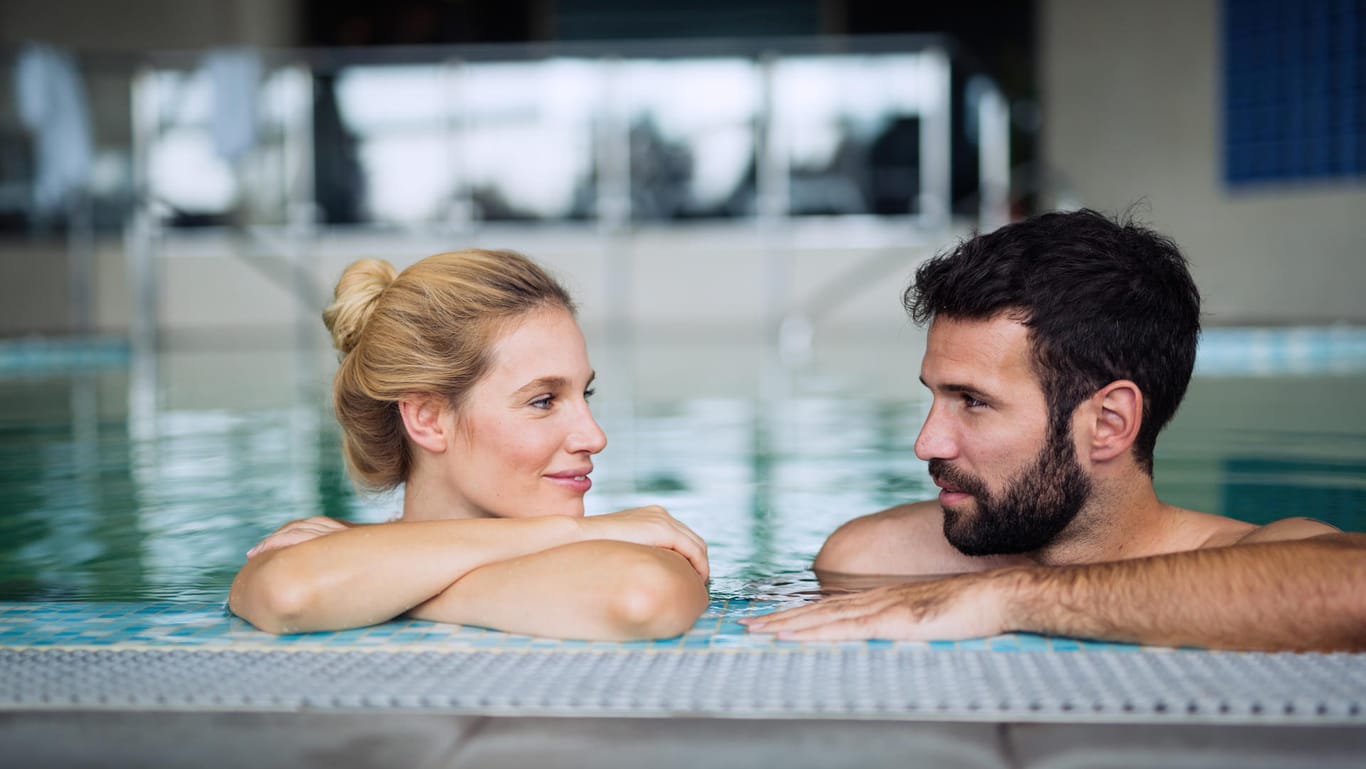 Eine Frau und ein Mann in einem Schwimmbecken: Um sich vor einem Burnout zu schützen und gesundheitlichen Problemen vorzubeugen, kann auch eine Kur helfen.