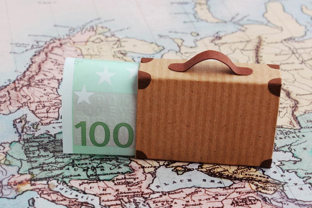 Koffer auf Europakarte mit Hundert-Euro-Schein im Gepäck