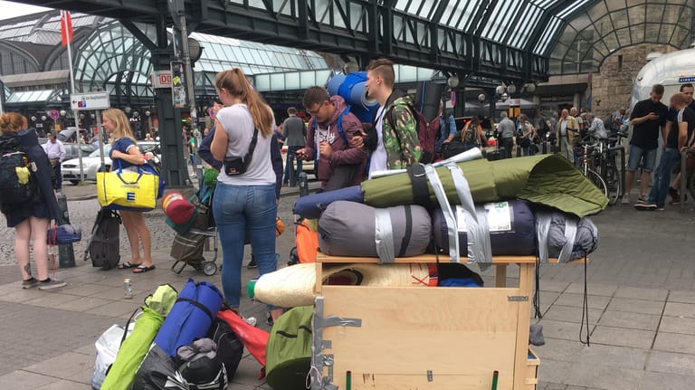 Reisenden stehenmit ihrem Gepäckwagen am Hauptbahnhof in Hamburg.