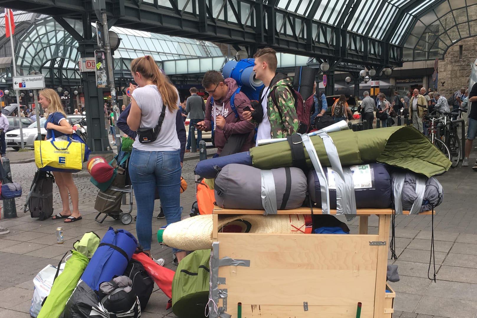 Reisenden stehenmit ihrem Gepäckwagen am Hauptbahnhof in Hamburg.