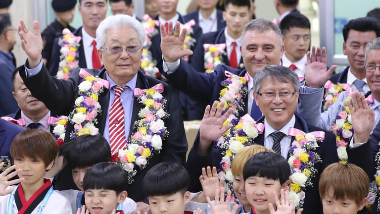 Chang Ung, Nordkoreas einziges Mitglied im Internationalen Olympischen Komitee(l.) und die nordkoreanische Taekwondo-Delegation bei ihrer Ankunft in Südkorea