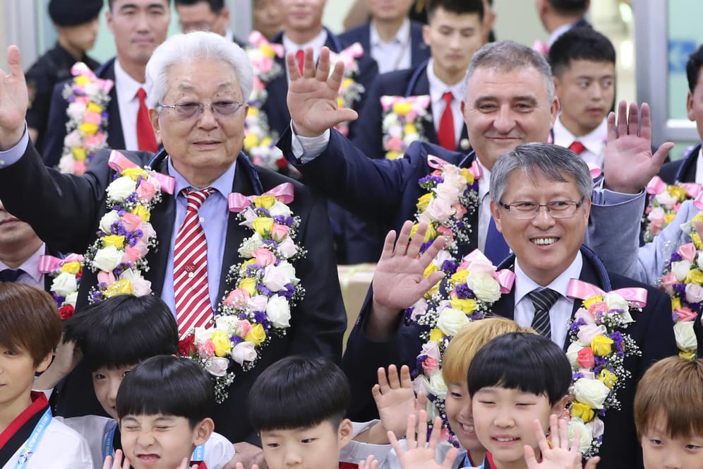 Chang Ung, Nordkoreas einziges Mitglied im Internationalen Olympischen Komitee(l.) und die nordkoreanische Taekwondo-Delegation bei ihrer Ankunft in Südkorea