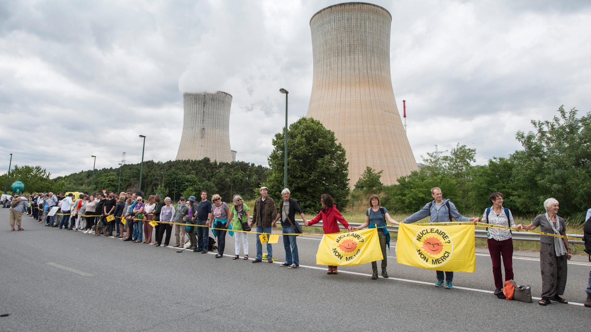 Teilnehmer bilden vor dem Atomkraftwerk Tihange (Belgien) bei der Protestaktion "Kettenreaktion" gegen belgische Atommeiler eine Menschenkette. Teilnehmer bilden vor dem Atomkraftwerk Tihange (Belgien) bei der Protestaktion "Kettenreaktion" gegen belgische Atommeiler eine Menschenkette.